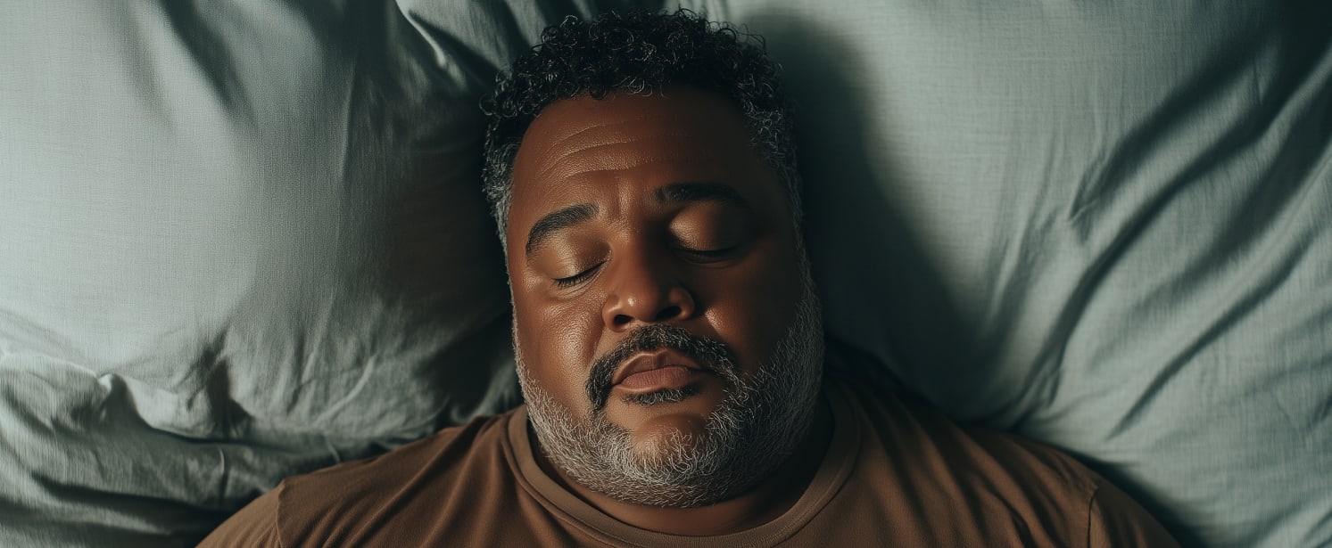 Plus size man laying down sleeping, snoring. 