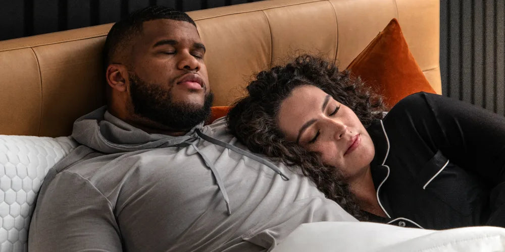 PLus size couple laying in bed.